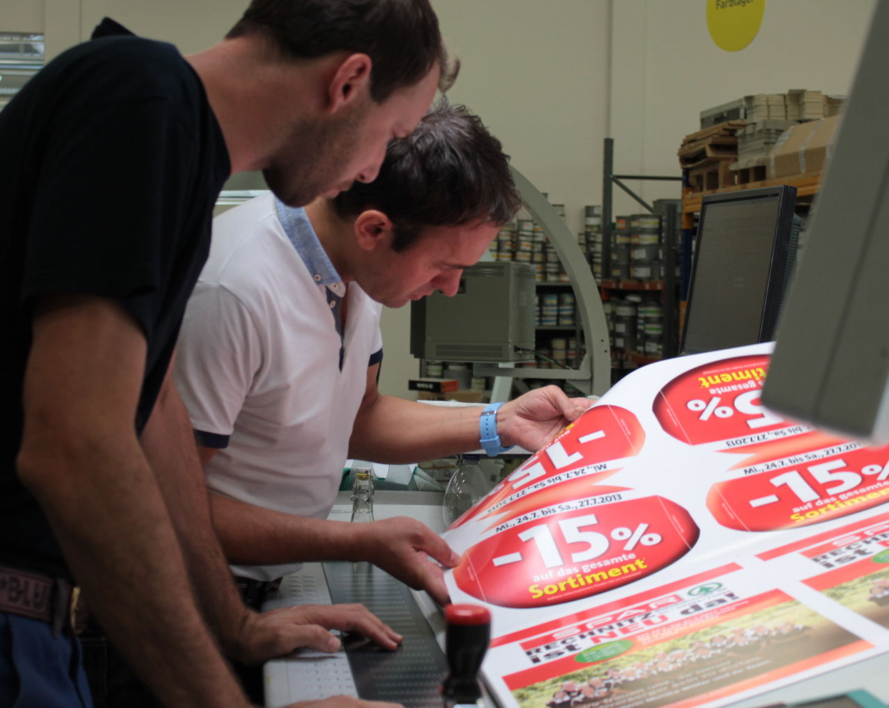 Mitarbeiter arbeiten am Selfmailer von Spar.